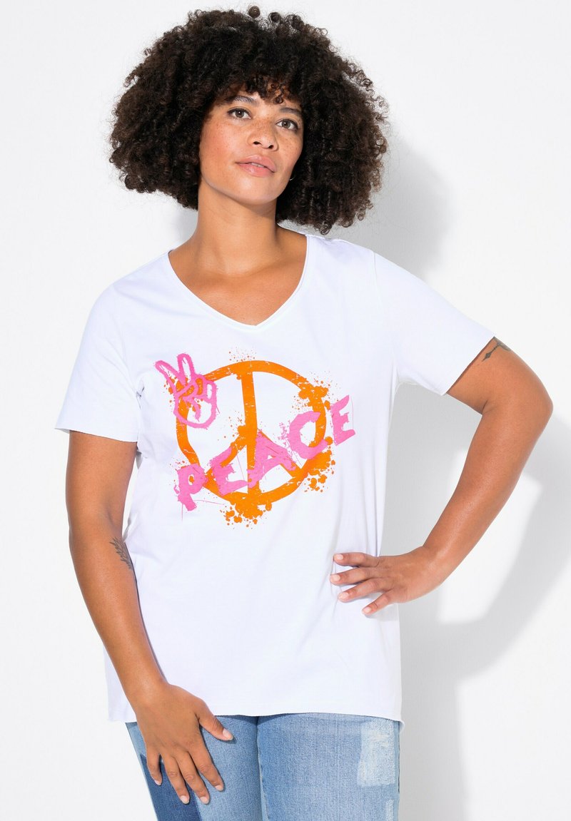 T-shirt en coton blanc avec un col en V, affichant un graphique "PEACE" rose et un motif de signe de paix orange, rehaussé de accents de coulures.