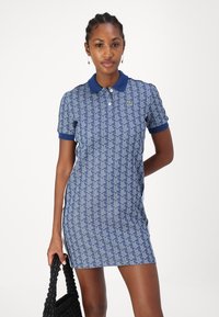 Robe polo bleu marine avec un tissu à motif géométrique, dotée d'un col contrastant, de manches courtes et d'une coupe slim.