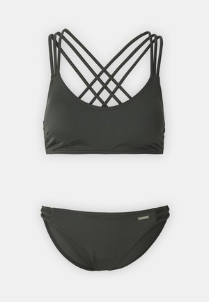 Bikini vert foncé avec un design croisé dans le dos, des bretelles fines et une texture unie. Le bas comporte trois sangles latérales parallèles.