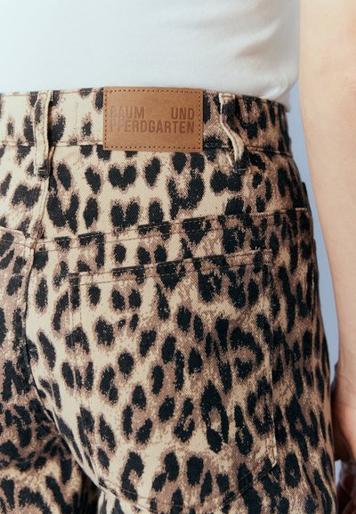 Leopard print denim pants with a high waist, featuring a brown leather label embossed with "BAUM UND PFERDGARTEN" on the waistband.