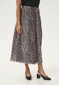 Leopardmønstret midiskørt i letvæv, elastisk talje, nuancer af beige og sort, parret med sorte lakerede hæle.