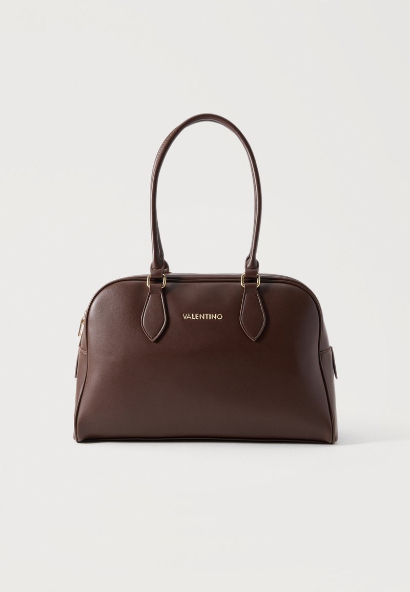 Σκούρα καφέ δερμάτινη τσάντα Valentino με δύο μακριές λαβές και χρυσά γράμματα λογότυπου σε ανοιχτό φόντο.