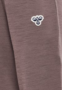 Grå tröjfabrics med en liten, vit och marinblå broderad bi-logotyp till vänster. Slät textur med ett subtilt stickat mönster.