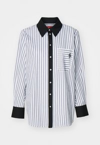 Chemise à manches longues, boutonnée, avec des rayures verticales bleues et blanches, col et poignets noirs, et une poche poitrine avec un logo.