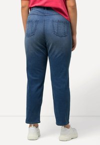 Siniset farkut suoralla leikkauksella, joissa on kaksi takataskua ja korkea vyötärö. Viimeistelty hieman haalistuneella pesulla.