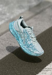 Baskets de sport bleu clair avec un dessus en maille texturée, motifs complexes, semelle épaisse et rembourrée, et système de la�çage.