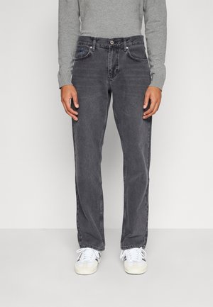 Jeans da uomo in denim grigio con taglio dritto, design a cinque tasche e dettagli di sbiaditura sottili. Abbinati a sneaker bianche e una maglietta grigia a maniche lunghe.