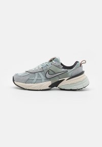 Zapatillas de running con una parte superior de malla gris claro con acentos en gris oscuro y verde menta, una suela texturizada y un forro negro.