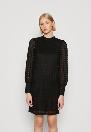 Black lace dress with a high neckline, long sheer sleeves, and a textured pattern. Knee-length with a fitted silhouette.