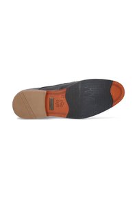 La semelle de la chaussure habillée noire et beige présente un caoutchouc noir texturé et un cuir beige lisse avec une adhérence à motif, un logo de marque en relief et un accent orange contrastant.