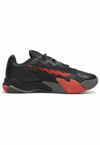 Zapatillas deportivas negras con parte superior texturizada, acentos rojos y una suela con patrón. Cuentan con un collar acolchado y un diseño aerodinámico.