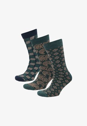 Drei Paar Socken in Dunkelgrün mit unterschiedlichen Mustern: einem karierten Design, einem spiralförmigen Motiv und einem floralen Muster, alle mit gerippten Bündchen.