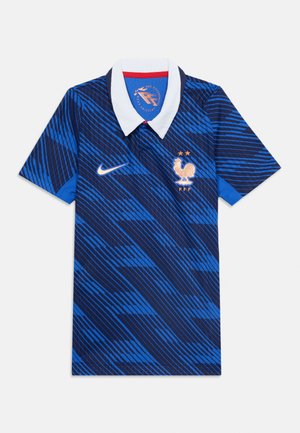 Maillot de football bleu à motifs à manches courtes avec col blanc, logo Nike blanc et emblème de l'équipe de France représentant un coq et deux étoiles.
