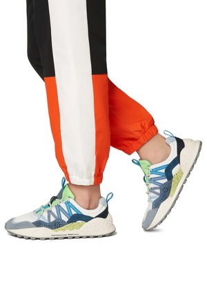 Mehrfarbige Sneaker aus Stoffmaterialien in Blau, Grün und Weiß mit strukturierten Akzenten, schnürbarem Design und einer robusten Sohle.