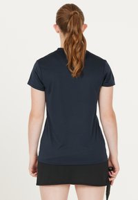 Marineblå t-shirt med korte ærmer til sportsbrug, lavet af glat og let stof. Bagfra ses en tætsiddende pasform og diskrete sømdetaljer.