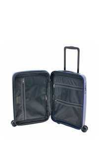 Valigia rigida di colore azzurro chiaro, apertura con zip, interno nero con tasche a rete e scomparti, manico telescopico, quattro ruote.