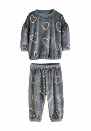 Een fluwelen loungewear-set met een grijze top met pofmouwen en gouden hartpatronen, gecombineerd met bijpassende broeken met elastische manchetten.