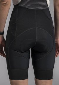 Black cycling shorts with padded seat area, featuring stretchy fabric, smooth seams, and a form-fitting design down to the knee.