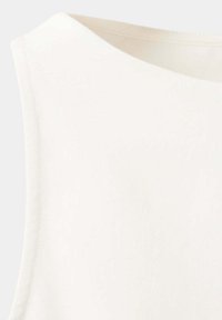 Gros plan d'un haut blanc sans manches avec un col rond et une texture de tissu lisse.