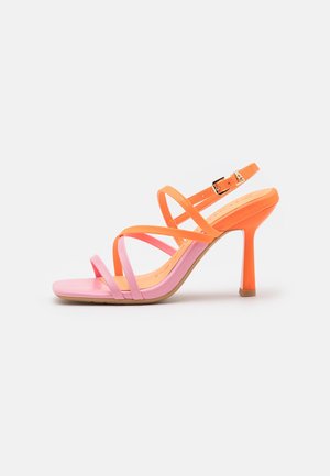 Sandale à talon haut à bout ouvert avec de fines lanières roses et orange et une boucle ajustable orange à la cheville sur fond blanc.