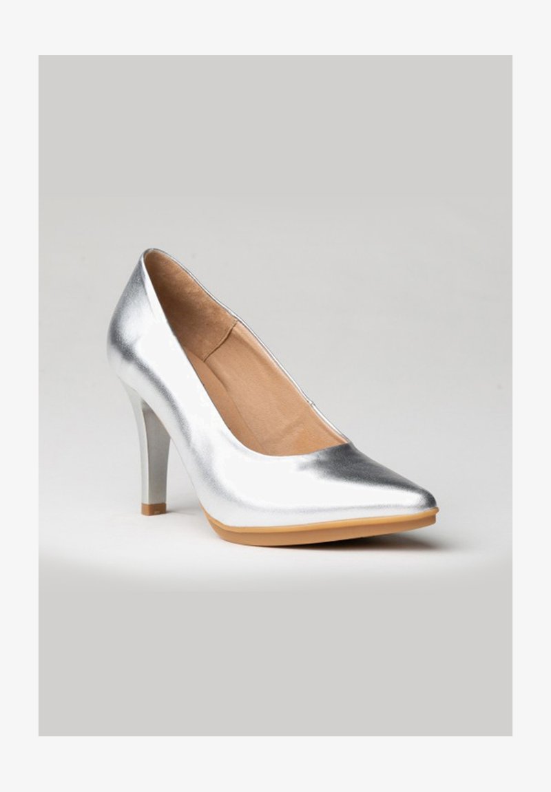 Zapato de tacón alto plateado con punta afilada, textura metálica suave y suela de color crema. Presenta un tacón delgado y cónico.