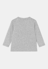 Dlouhý rukáv šedé tričko vyrobené z měkké látky, s kulatým výstřihem a texturovaným povrchem. Jednoduchý design bez vzorů nebo akcentů.