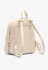 Plecak z kremowej syntetycznej skóry z teksturowanym, tkanym bocznym panelem, złotym okuciem, podwójnymi regulowanymi paskami i zamknięciem na zamek.