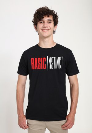 Sort bomulds T-shirt med teksten "BASIC" i rød og "INSTINCT" i hvid, med et moderne skrifttype. Kortærmet og med rund halsudskæring.