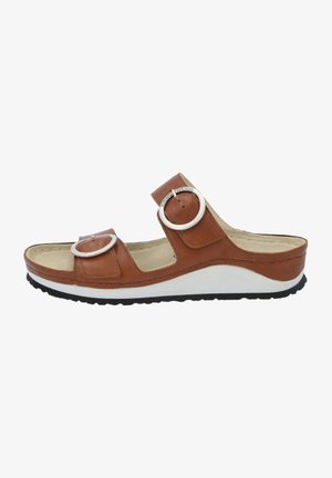 Brown leather wedge sandal with two circular buckles, open toe, and textured insole. White midsole and black rubber outsole for grip.