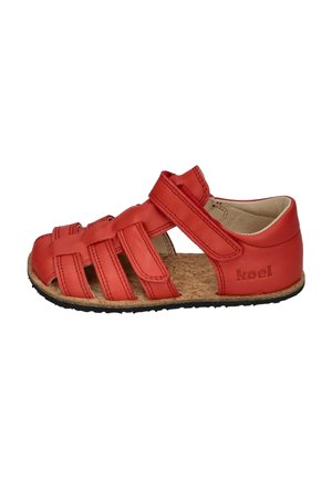 Red children's leather sandal with multiple straps, adjustable Velcro closure, cork insole, and black rubber sole, branded "koel" on the heel.