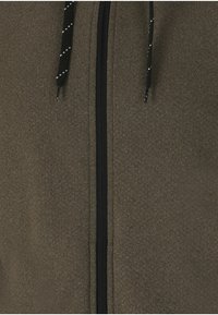 Veste zippée marron en tissu texturé, dotée d'une fermeture éclair noire et de cordons de serrage noirs avec des accents blancs.