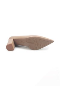 Zapato de tacón beige con punta afilada y suela de goma texturizada. El tacón cuadrado ofrece estabilidad. Acabado suave y brillante con detalles sutiles.