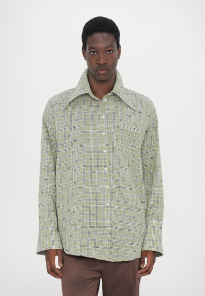 Green plaid button-up shirt with a large collar, featuring white and navy accents, relaxed fit, and a single chest pocket.