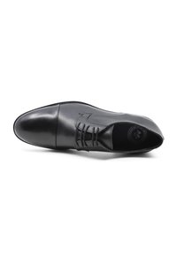 Scarpe eleganti da uomo in pelle nera con una texture liscia, punta affusolata e dettagli cuciti. Presentano un design con lacci e un logo rotondo all'interno.