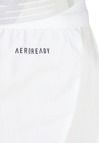 Witte sportieve shorts met een textuurstof, AEROREADY-logo en een mesh-paneel aan de zijkant voor ademend vermogen.