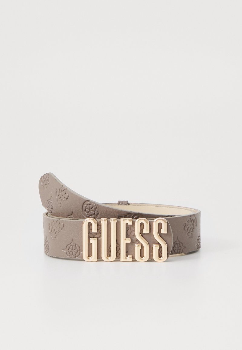 Ceinture en cuir taupe embossée d’un motif floral et une grande boucle dorée portant l’inscription "GUESS" en majuscules.