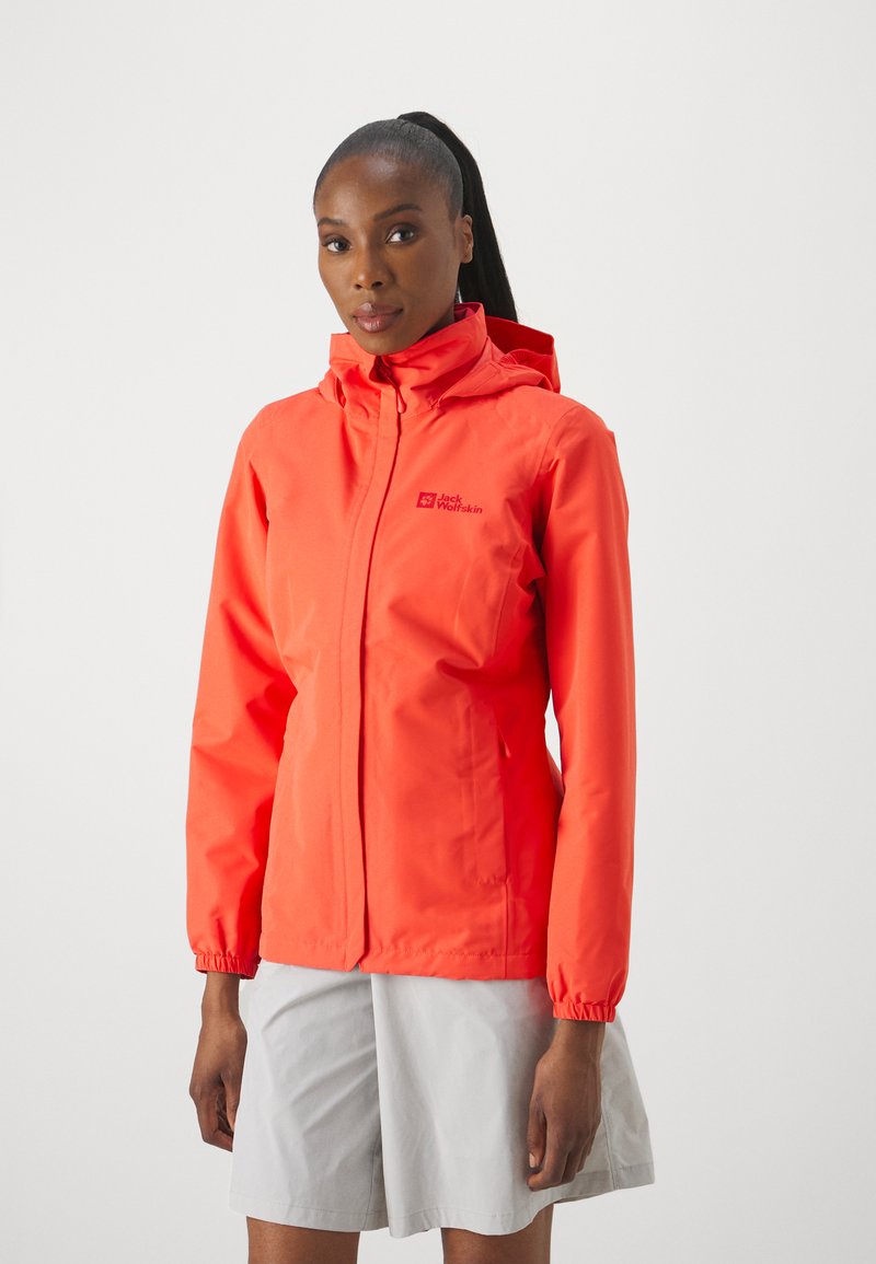 Veste imperméable de couleur orange vif, avec une capuche, une fermeture éclair et des poignets élastiques. Logo affiché de manière proéminente sur la poitrine gauche.