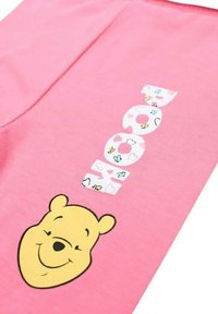 Chemise en coton rose avec un graphisme du visage souriant de Winnie l'Ourson et le mot "AMOUR" décoré de cœurs et de papillons.