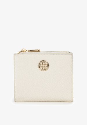 Cartera de cuero con textura cremosa con cremallera dorada y un emblema redondo dorado con un diseño de trébol de cuatro hojas en el frente.