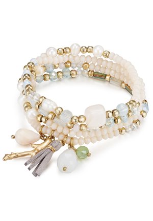 Perlenarmband in hellcreme und goldenen Tönen, mit Perlen, Kristallen und verschiedenen Steinen; beinhaltet einen Anhänger und Quastenakzente.