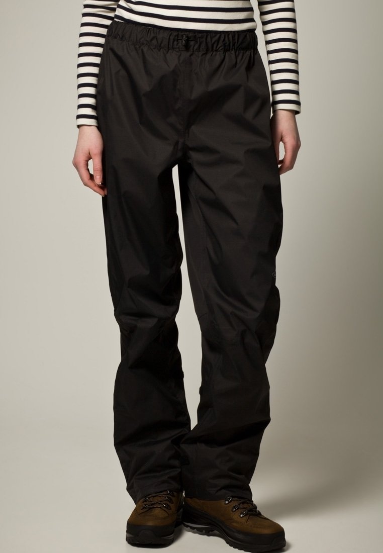 Černé outdoorové kalhoty s elastickým pasem, lehkým materiálem, zúženými nohavicemi a precizním šitím; nošeny s hnědými turistickými botami.