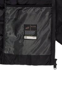 Interno di giacca imbottita nera con tasca in rete, etichetta con dettagli per la cura e chiusura con zip nera. Tessuto strutturato con cuciture visibili.