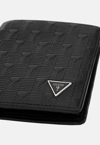 Portefeuille noir avec un motif texturé, des accessoires en argent en forme de triangle et un logo embossé, fabriqué en matériau synthétique.