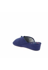 Zapatilla de tela azul marino con punta redondeada, plantilla acolchada con un patrón floral y un pequeño lazo decorativo en la parte delantera.