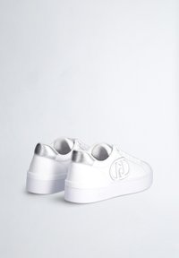Sneakers bianchi con finitura in pelle liscia, dettagli metallici d'argento sul tallone e una robusta suola in gomma bianca, con logo.