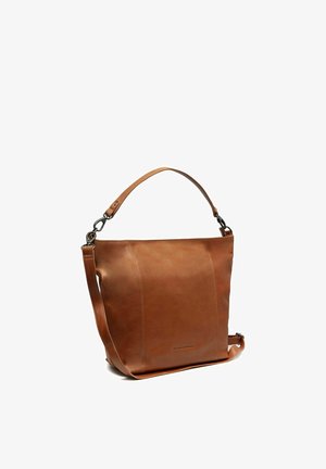 Braune Ledertasche mit zwei verstellbaren Riemen und minimalen Nähten, steht aufrecht vor weißem Hintergrund.