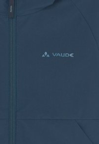 Giacca Vaude blu navy con zip completa, caratterizzata da una superficie liscia e un logo visibile sul lato sinistro.
