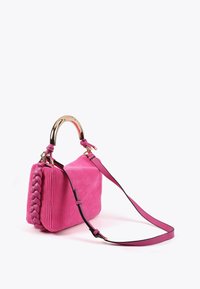 Una vivace borsa a mano rosa con una superficie testurizzata e un manico intrecciato, dotata di un manico ad arco in metallo dorato e di una tracolla regolabile.
