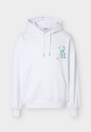 Sweat à capuche blanc avec poche frontale et illustration verte d'un ours jouant au golf sur le côté gauche de la poitrine.
