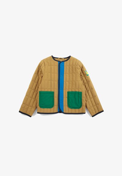 Veste matelassée marron clair avec patte de boutonnage bleue, poches avant vertes, bordure noire et petit patch sur la manche gauche.